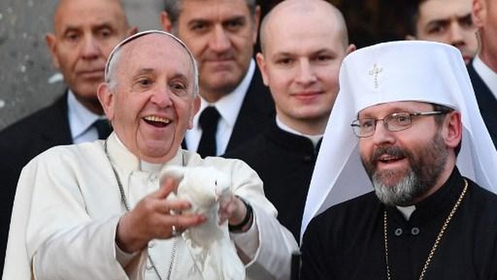 Pope Francis (L) and Greek Catholic Archbishop Sviatoslav Shevchuk free doves during a visit to the Roman basilica Santa Sofia and the Ukrainian Greek Catholic Community, on January 28, 2018 in Rome. (Photo by Alberto PIZZOLI / AFP)