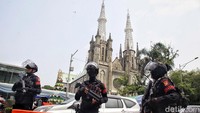 Polisi dengan senjata laras panjang berjaga di depan Gereja Katedral.