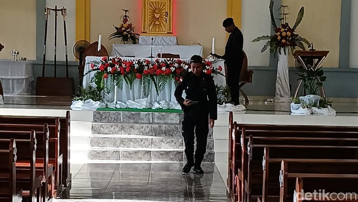 Personel Brimob sterilisasi gereja Roh Kudus Labuan Bajo menggunakan metal detector sebelum dimulainya misa Natal, Minggu (24/12/2023).