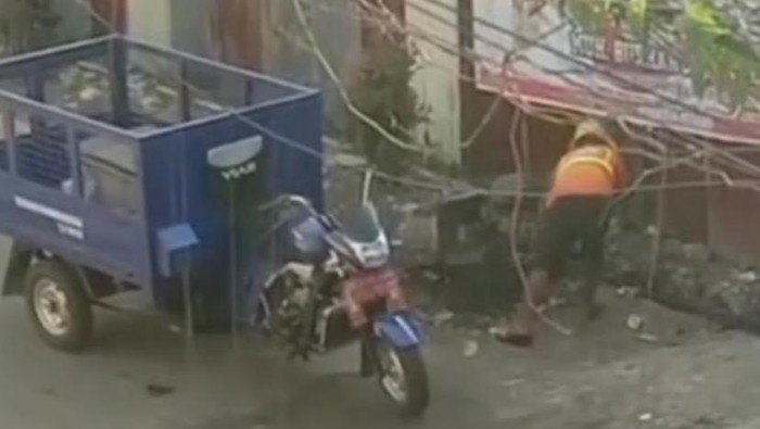 Petugas kebersihan yang buang sampah ke selokan
