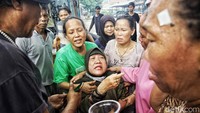 Warga berusaha menenangkan korban kebakaran.