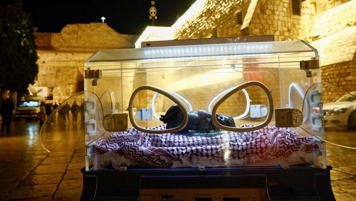 Instalasi Patung Bayi Yesus di Inkubator untuk Dukung Gaza An installation by Rana Bishara shows a figure of baby Jesus, made by Sana Fara Bishara, inside an incubator in front the Church of the Nativity in support of Gaza, in Bethlehem, in the Israeli-occupied West Bank, December 24, 2023. REUTERS/Clodagh Kilcoyne