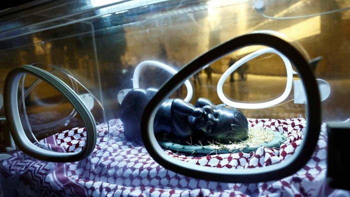 Instalasi Patung Bayi Yesus di Inkubator untuk Dukung Gaza An installation by Rana Bishara shows a figure of baby Jesus, made by Sana Fara Bishara, inside an incubator in front the Church of the Nativity in support of Gaza, in Bethlehem, in the Israeli-occupied West Bank, December 24, 2023. REUTERS/Clodagh Kilcoyne