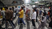 Tampak warga menyeberangi jalan secara bersama-sama.