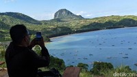 Seorang pengendara sedang mengabadikan keindahan panorama alam Teluk Popoh Tulungagung.