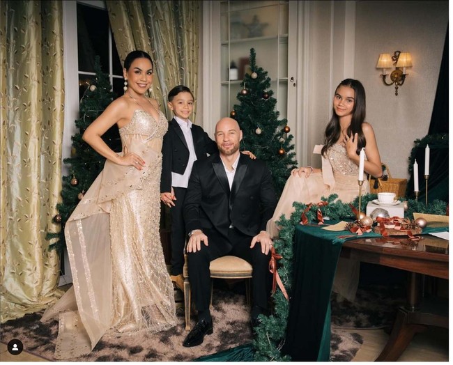 Melaney Ricardo dan suaminya Tyson James Lynch membuat foto Natal dengan gaya glamour. Melaney, Tyson dan dua anak mereka Chloe Valentine Lynch serta Courage Jordan Lynch berpose di ruang makan dengan latar pohon cemara yang tampak dihias dengan bola-bola lampu warna putih dan emas. Melaney dan putrinya Chloe mengenakan gaun warna putih, sedangkan Tyson dan Courage memakai setelan hitam. Foto: @melaney_ricardo