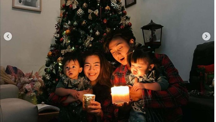Para artis Indonesia yang merayakan Natal berfoto bersama keluarga mereka dengan latar pohon Natal.