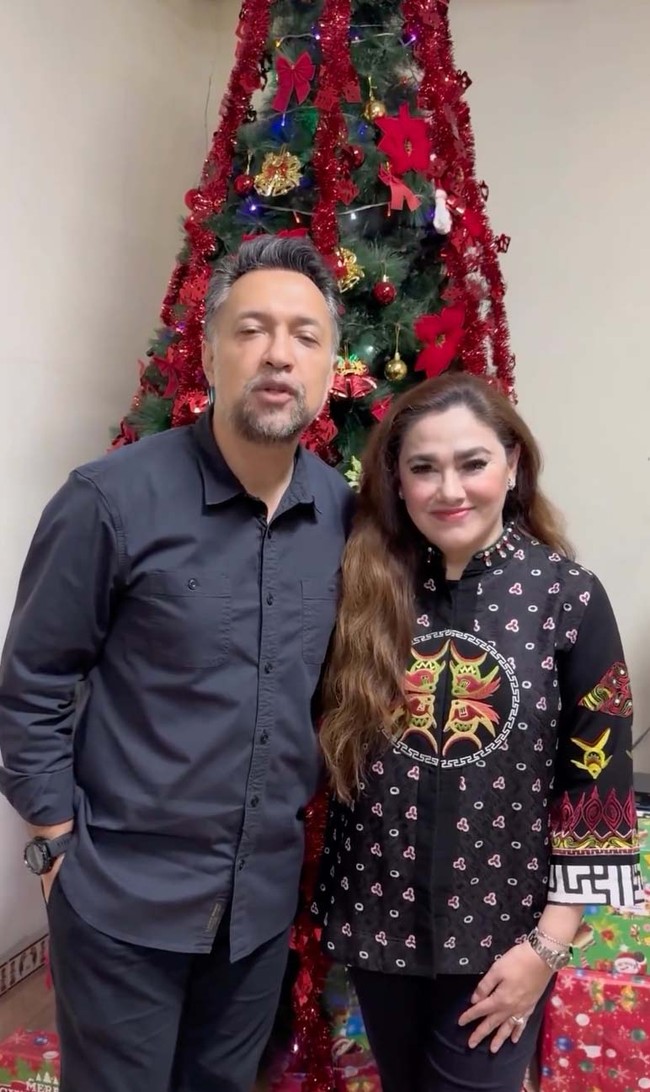 Pasangan Ari Sihasale dan Nia Zulkarnaen merayakan Natal di Papua. Keduanya berpose dengan latar pohon Natal yang dekorasinya meriah bernuansa merah. Foto: dok. Instagram Ari Sihasale
