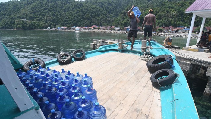 Pekerja mengangkut galon berisi air minum ke dalam kapal di Morowali, Sulawesi Tengah, Selasa (26/12/2023). Air minum tersebut dibawa dan dijual ke masyarakat di kepulauan Menui dan dijual dengan harga Rp 13 ribu per galon. ANTARA FOTO/Mohamad Hamzah/foc.