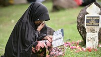 Beberapa melantuntan ayat suci Alquran di pusara terakhir. Diketahui, Bencana gempa yang disusul gelombang tsunami pada Minggu 26 Desember 2004 atau 19 tahun lalu itu mengakibatkan sekitar 230 ribu orang meninggal dunia, 139 ribu unit rumah rusak serta 85 persen infrastruktur hancur di Provinsi Aceh. REUTERS/Riska Munawarah