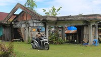 Warga melintas di depan salah satu bangunan rumah yang rusak akibat bencana gempa dan gelombang tsunami 26 Desember 2004 di Desa Padang Seurahet, Johan Pahlawan, Aceh Barat. ANTARA FOTO/Syifa Yulinnas
