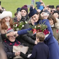 Seusai ibadah, Pangeran Louis menemani ibunya menyapa warga yang telah menanti mereka. Antusias, warga setempat juga memberi bunga dan kado untuk keluarga Kerajaan. Pangeran Louis pun tak kelawatan mendapat hadiah. (Foto: AP Photo/Kin Cheung)