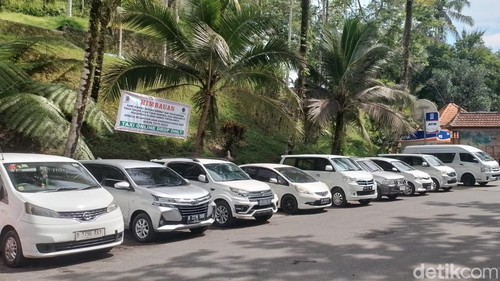 Spanduk larangan mangkal bagi taksi online terpasang di area parkir mobil objek wisata Pura Tirta Empul, Desa Manukayalet, Kecamatan Tampaksiring, Gianyar, Bali. (Foto: detikBali/Putu Krista)