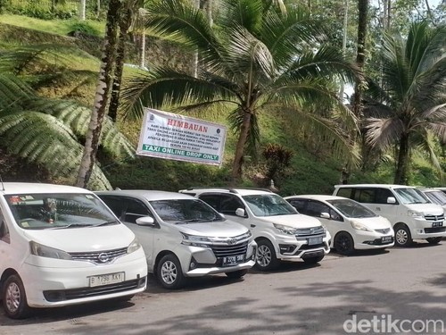 Spanduk larangan mangkal bagi taksi online terpasang di area parkir mobil objek wisata Pura Tirta Empul, Desa Manukayalet, Kecamatan Tampaksiring, Gianyar, Bali. (Foto: detikBali/Putu Krista)