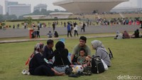 Di beberapa titik, ada pengunjung yang duduk-duduk di area taman kawasan Monas.
