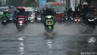 Beberapa dari pemotor nampak menaikkan kaki untuk menghindari genangan air.