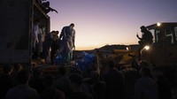 Fotografer AFP melihat seseorang menurunkan puluhan kantong jenazah berwarna biru ke dalam tanah di Rafah. Jenazah itu dikuburkan dalam satu liang lahad.  