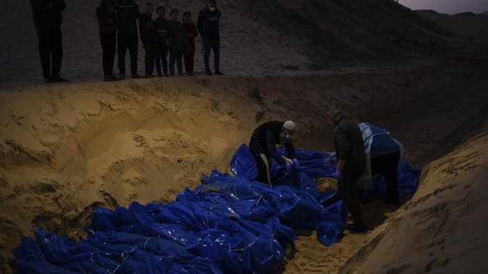 Medics unload the bodies of Palestinians killed in fighting with Israel and turned over by the Israeli military during a mass funeral in Rafah, Gaza Strip, Tuesday, Dec. 26, 2023.(AP Photo/Fatima Shbair)