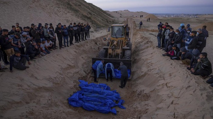 Israel Kembalikan Jenazah 80 Warga Gaza, Langsung Dikubur Massal Medics unload the bodies of Palestinians killed in fighting with Israel and turned over by the Israeli military during a mass funeral in Rafah, Gaza Strip, Tuesday, Dec. 26, 2023.(AP Photo/Fatima Shbair)