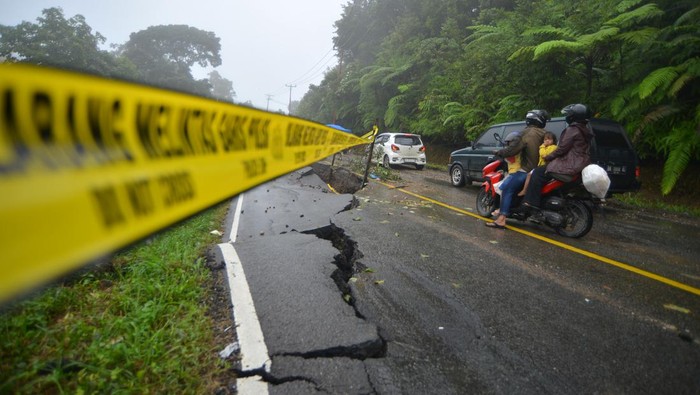 Jalan amblas di Limapuluhkota Warga berada di dekat jalan yang amblas di kelok 17 Koto Alam, Limapuluhkota, Sumatera Barat, Rabu (27/12/2023). Intensitas hujan tinggi sejak Senin (25/12) membuat ruas jalan utama menuju provinsi Riau itu amblas dan longsor sehingga arus lalu-lintas tersendat karena diberlakukan sistem buka-tutup. ANTARA FOTO/Iggoy el Fitra/Spt.