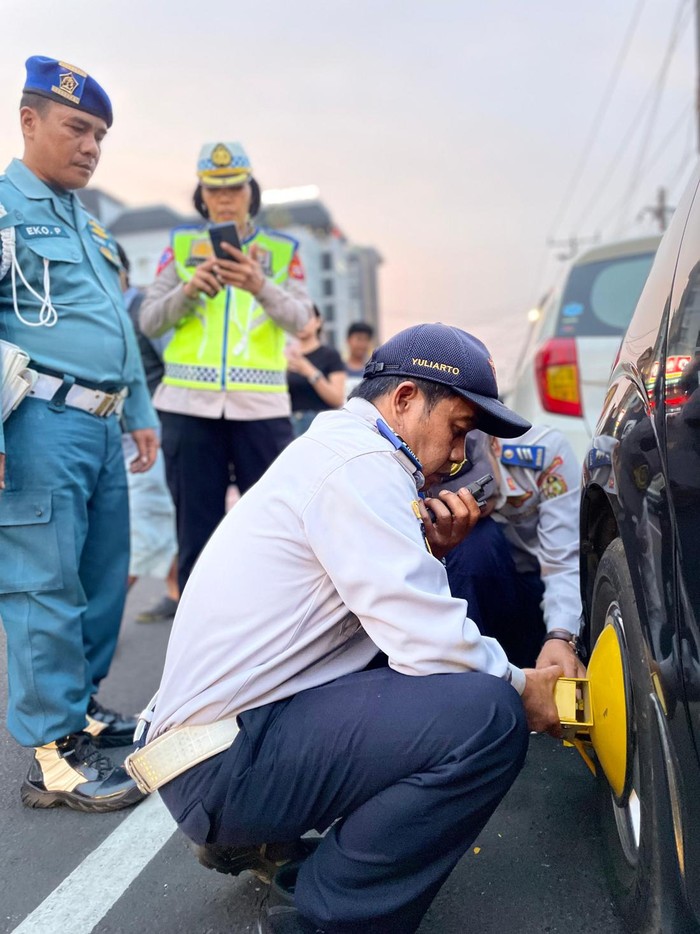 Dishub Kota Jogja menggembok mobil yang parkir sembarangan selama libur Natal 25-26 Desember 2023.