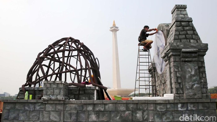 Pekerja menyelesaikan dekorasi untuk mobil hias yang akan digunakan pada Jakarnaval sambut tahun baru 2024 di Monas, Jakarta, Rabu (27/12/2023).