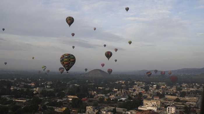 Menikmati Lanskap Piramida Matahari Meksiko dari Balon Udara Hot air balloons teeming with tourists fly over the Sun pyramid at the Teotihuacan archaeological site, just north of Mexico City, Sunday, Dec. 24, 2023. (AP Photo/Marco Ugarte)