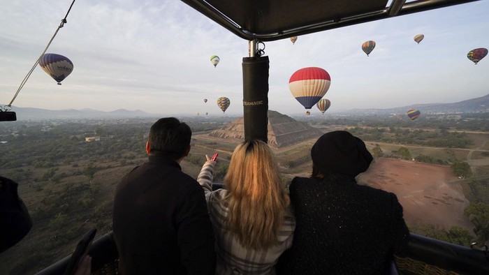 Menikmati Lanskap Piramida Matahari Meksiko dari Balon Udara Hot air balloons teeming with tourists fly over the Sun pyramid at the Teotihuacan archaeological site, just north of Mexico City, Sunday, Dec. 24, 2023. (AP Photo/Marco Ugarte)