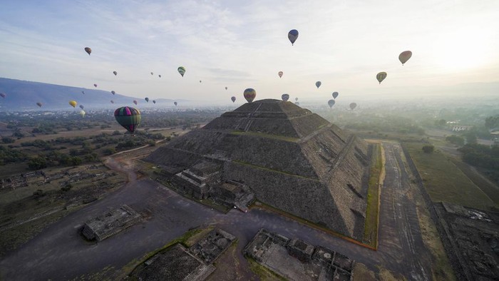 Menikmati Lanskap Piramida Matahari Meksiko dari Balon Udara Hot air balloons teeming with tourists fly over the Sun pyramid at the Teotihuacan archaeological site, just north of Mexico City, Sunday, Dec. 24, 2023. (AP Photo/Marco Ugarte)