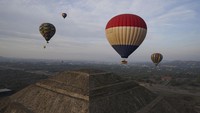 Balon udara yang membawa turis terbang di atas piramida Matahari di situs arkeologi Teotihuacan, tepat di utara Mexico City.   
