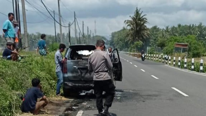 Polisi saat meninjau sebuah mobil yang terbakar di Lendah, Kulon Progo, pada Rabu ini (27/12/2023).