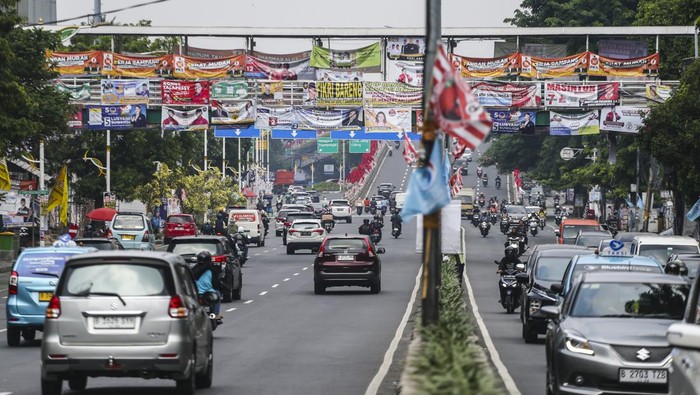 Kendaraan melintas di bawah Jembatan Penyeberangan Orang (JPO) yang tertutup oleh alat peraga kampanye Pemilu 2024 di Jakarta, Rabu (27/12/2023). Pemasangan APK Pemilu 2024 tersebut melanggar Peraturan KPU yang melarang pemasangan atribut partai atau caleg di fasilitas umum. ANTARA FOTO/Rivan Awal Lingga/tom.