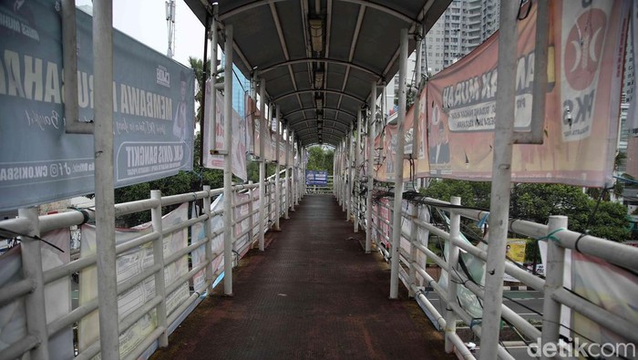 Pelanggaran! JPO di Jakarta Tertutup APK Pemilu Kendaraan melintas di bawah Jembatan Penyeberangan Orang (JPO) yang tertutup oleh alat peraga kampanye Pemilu 2024 di Jalan KH Mas Mansyur, Tanah Abang, Jakarta Pusat, Rabu (27/12/2023).