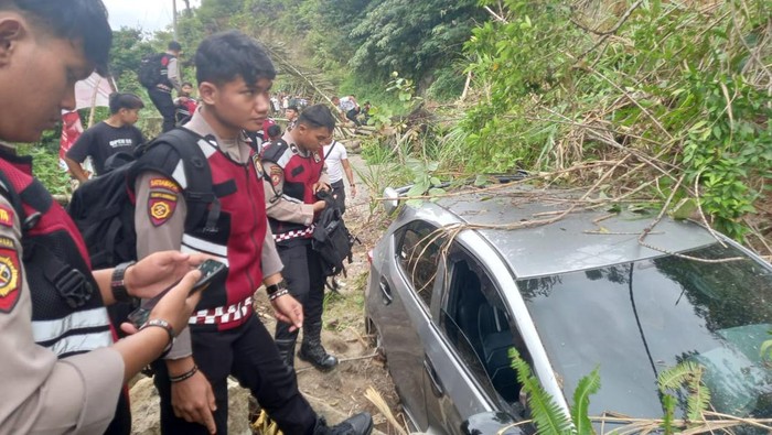 Pihak kepolisian saat mengevakuasi mobil tertimpa longsor. (Foto: Dok. Polres Taput).