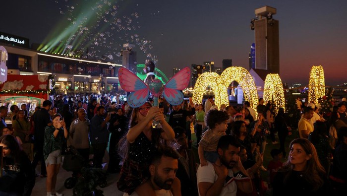 People gather around a Christmas tree, in Dubai, United Arab Emirates, December 23, 2023. REUTERS/Amr Alfiky