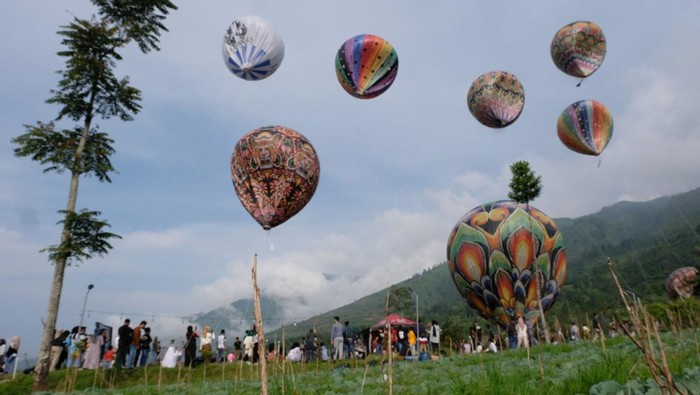 Sejumlah pengunjung menyaksikan penerbangan balon tradisional di Kahyangan Sky View kawasan lereng Bukit Seroja, Desa Maron, Garung Wonosobo, Jawa Tengah , Kamis (28/12/2023).  Penerbangan belasan balon tradisional berukuran besar di kawasan wisata alam Telaga Menjer tersebut sebagai atraksi wisata untuk menarik pengunjung saat musim libur Natal dan tahun baru 2024. ANTARA FOTO/Anis Efizudin/nym.