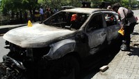 Polisi mengecek kondisi mobil yang dibakar massa di Sentani, Kabupaten Jayapura, Papua, Kamis (28/12/2023).