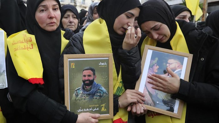 Mourners react during the funeral procession of a Hezbollah fighter and other two civilians who were killed by an Israeli airstrike that hit their house Tuesday night, in Bint Jbeil, South Lebanon, Wednesday, Dec. 27, 2023. One Hezbollah fighter and two civilians, a newlywed couple, were killed in an overnight Israeli strike on a family-owned residential building in the town of Bint Jbeil, local residents and state media said Wednesday.(AP Photo/Mohammed Zaatari)