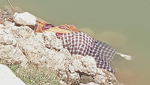 Jasad Hasan Nur ditutupi kain sarung oleh warga seusai ditemukan di Bendungan Batu Bulan, Sumbawa, NTB, Kamis (28/12/2023). (Foto: Istimewa)