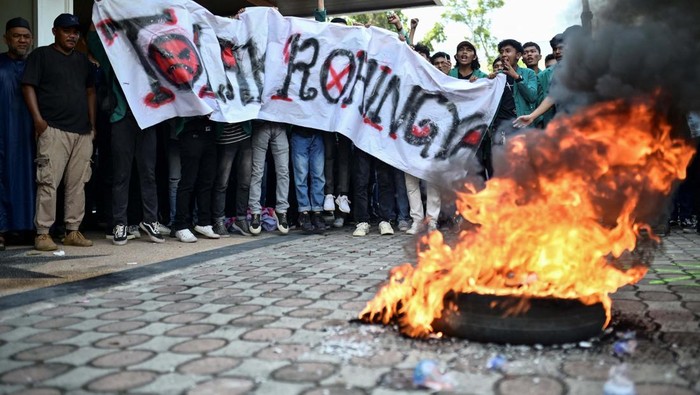 Indonesian protesters burn a tire during a protest for the deportation of the Rohingya refugees in Banda Aceh, Aceh province, Indonesia December 27, 2023. REUTERS/Riska Munawarah