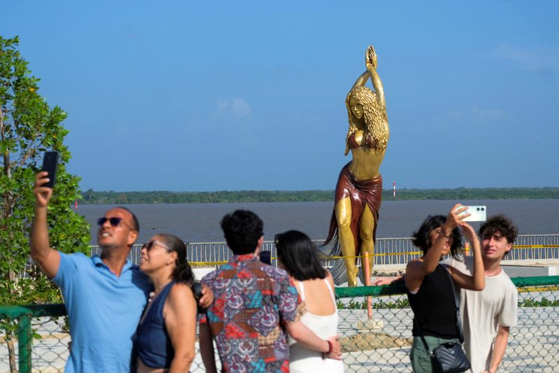 People pose for photos next to the statue of Colombian singer Shakira at the Gran Malecon in Barranquilla, in Barranquilla, Colombia, December 27, 2023. REUTERS/Carlos Parra Rios NO RESALES. NO ARCHIVES.