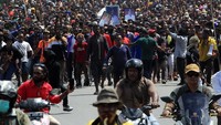 Warga mengarak jenazah Lukas Enembe dari Bandara Sentani ke STAKIN.  