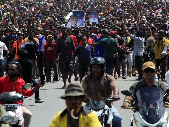 Arak-arakan warga saat membawa peti jenazah mantan Gubernur Papua Lukas Enembe ke tempat persemayaman di Koya Tenga, Kota Jayapura, Papua, Kamis (28/12/2023). Peristiwa tersebut diwarnai kericuhan yaitu massa membakar mobil dan menyerang aparat. ANTARA FOTO/Gusti Tanati