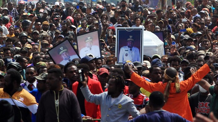 Arak-arakan warga saat membawa peti jenazah mantan Gubernur Papua Lukas Enembe ke tempat persemayaman di Koya Tenga, Kota Jayapura, Papua, Kamis (28/12/2023). Peristiwa tersebut diwarnai kericuhan yaitu massa membakar mobil dan menyerang aparat. ANTARA FOTO/Gusti Tanati