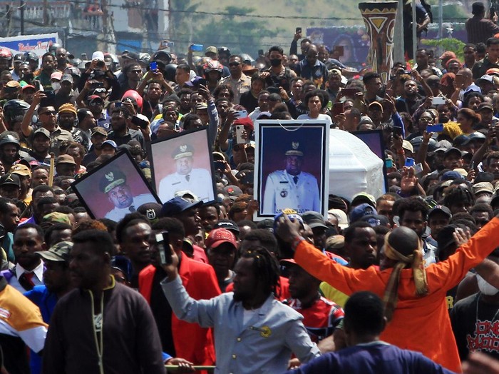 Arak-arakan warga saat membawa peti jenazah mantan Gubernur Papua Lukas Enembe ke tempat persemayaman di Koya Tenga, Kota Jayapura, Papua, Kamis (28/12/2023). Peristiwa tersebut diwarnai kericuhan yaitu massa membakar mobil dan menyerang aparat. ANTARA FOTO/Gusti Tanati