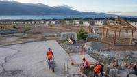 Sejumlah pekerja merampungkan pembuatan trotoar jalan di kawasan Huntap Talise di Palu, Sulawesi Tengah, Rabu (27/12/2023).