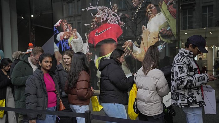 Potret Warga Inggris Berburu Diskon di Boxing Day Shoppers walks on Oxford Street during the Boxing Day sales in London, Tuesday, Dec. 26, 2023. (AP Photo/Kin Cheung)