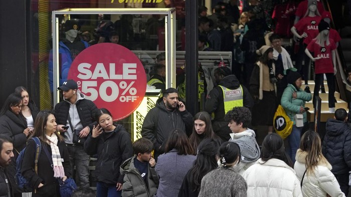Potret Warga Inggris Berburu Diskon di Boxing Day Shoppers walks on Oxford Street during the Boxing Day sales in London, Tuesday, Dec. 26, 2023. (AP Photo/Kin Cheung)