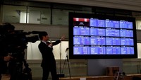Seorang produser TV menunjukkan harga penutupan indeks Nikkei di papan kutipan saham setelah upacara menandai berakhirnya perdagangan tahun 2023 di Tokyo Stock Exchange (TSE) di Tokyo.  