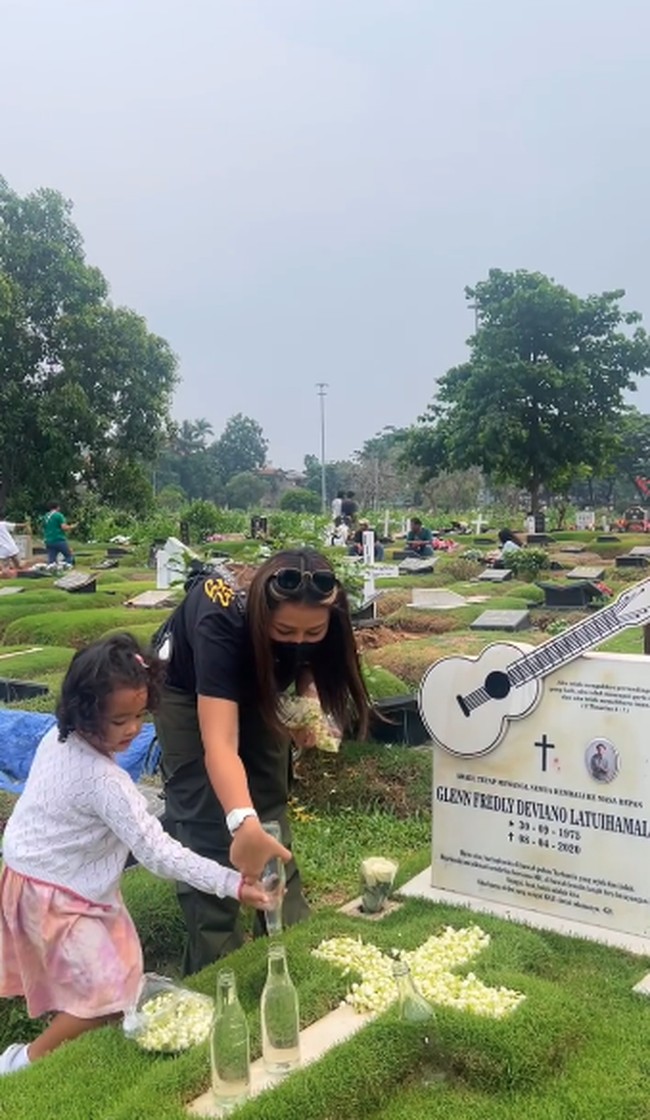 Saat sampai dimakam Glenn Fredly, terlihat Gewa ikut membantu sang ibunda menyiramkan air ke makam. Gewa mengenakan dress warna pink dan cardigan putih. Foto: Instagram @mutia_ayuu